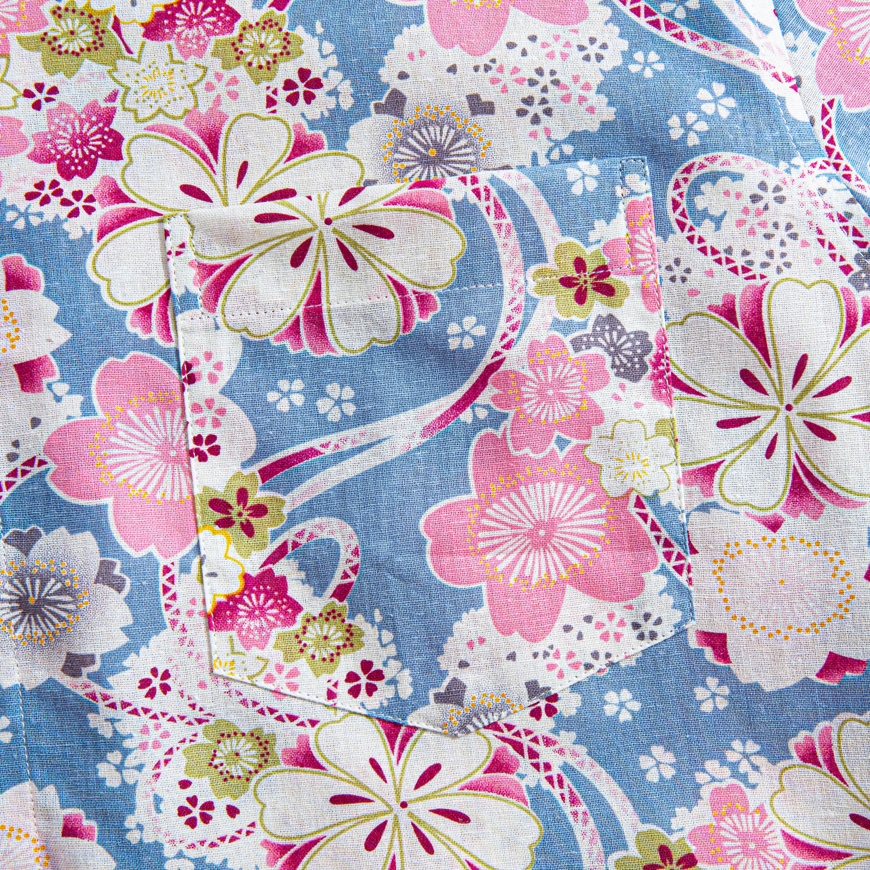 Chest pocket detail with sakura blossom pattern on blue cotton shirt