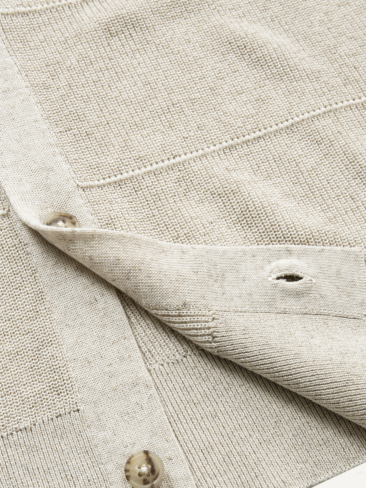 Close-up of clean ribbed hem on oatmeal horizontal textured knit cardigan
