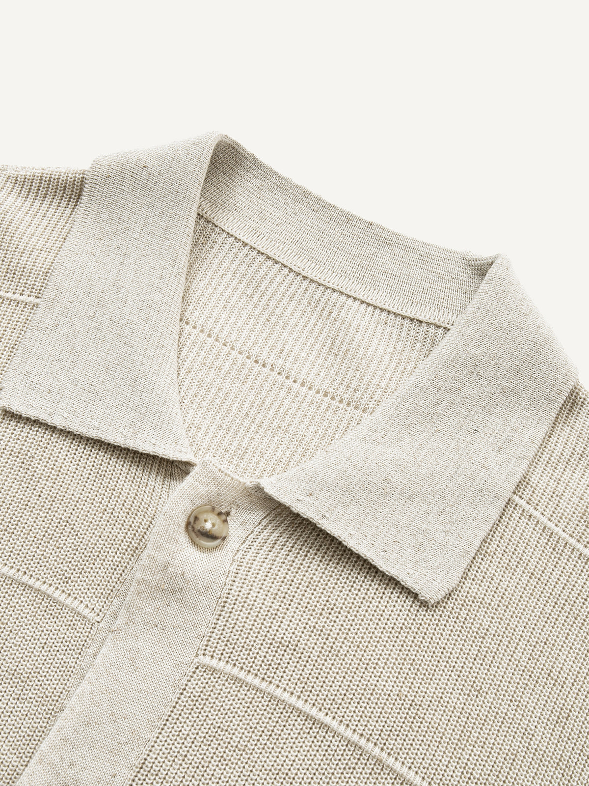 Close-up of refined polo collar and top placket on oatmeal textured knit cardigan