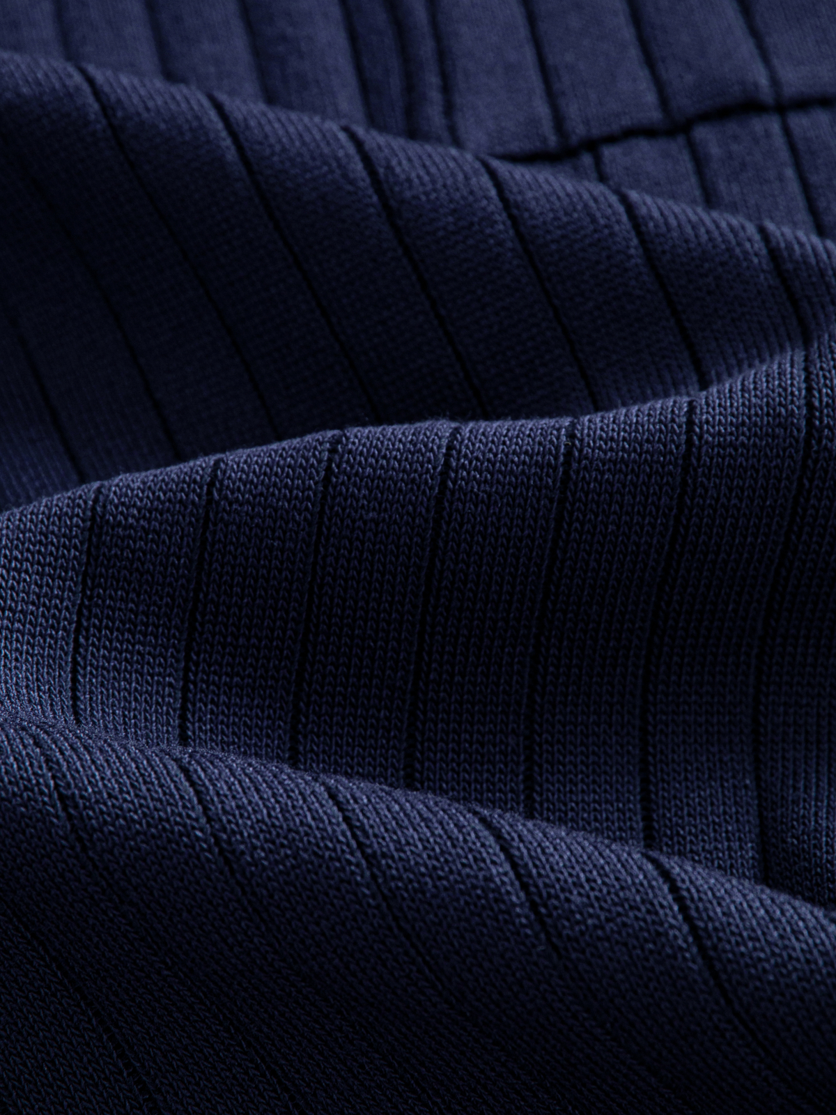 Close-up texture of wide vertical rib knit fabric on OROMEN Contrast-Tipped Ribbed Knit Polo