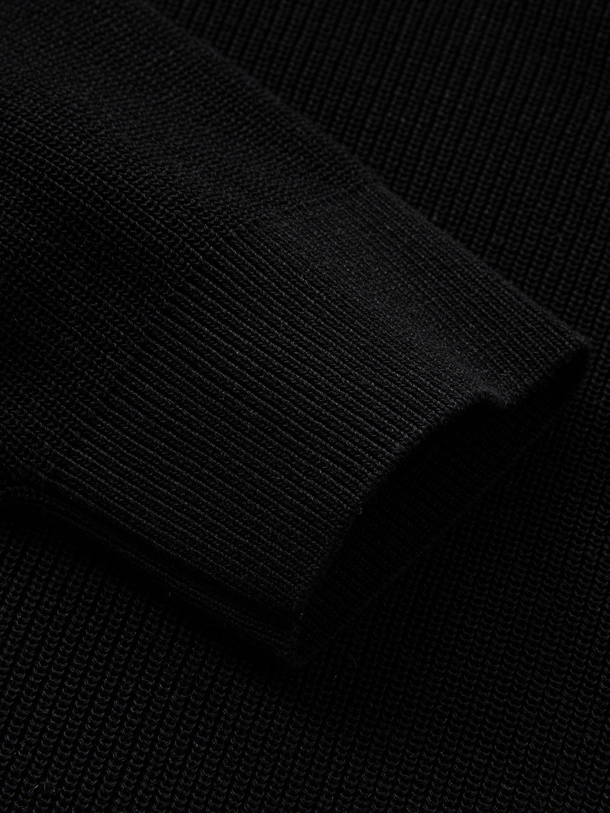 Detailed view of long sleeve ribbed cuffs on black polo knit cardigan