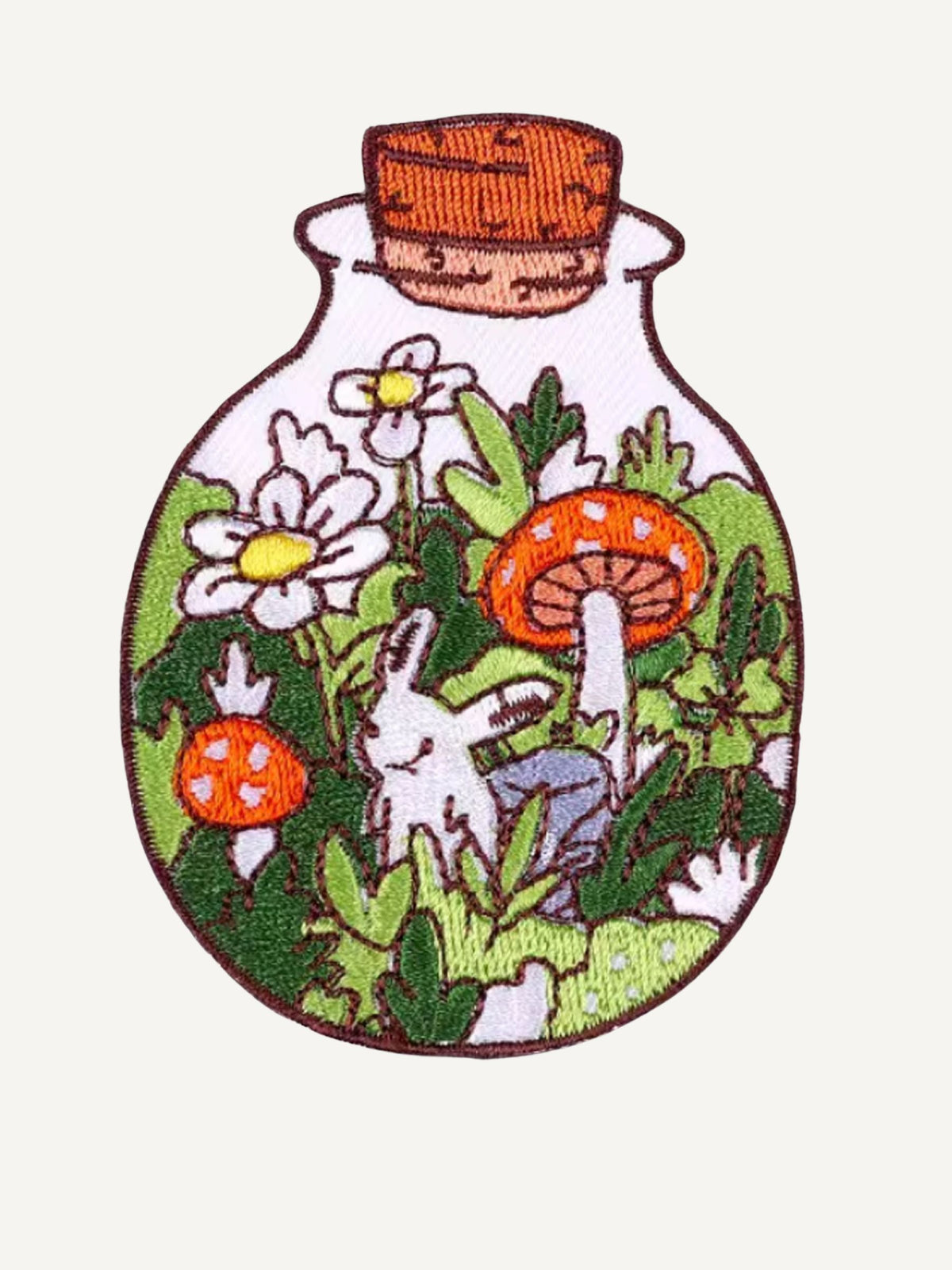 Intricate bottle garden embroidery artwork on OROMEN T-shirt