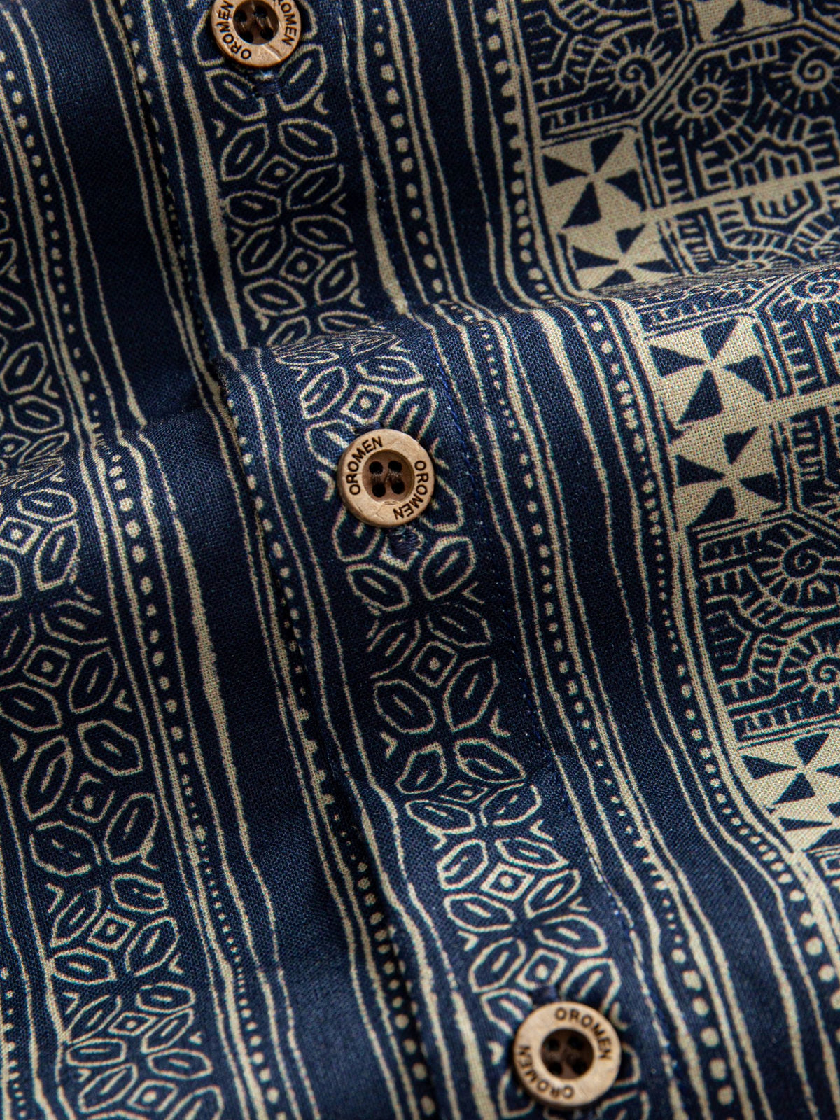 Natural coconut button closure and front placket detail of OROMEN Indigo Batik Shirt
