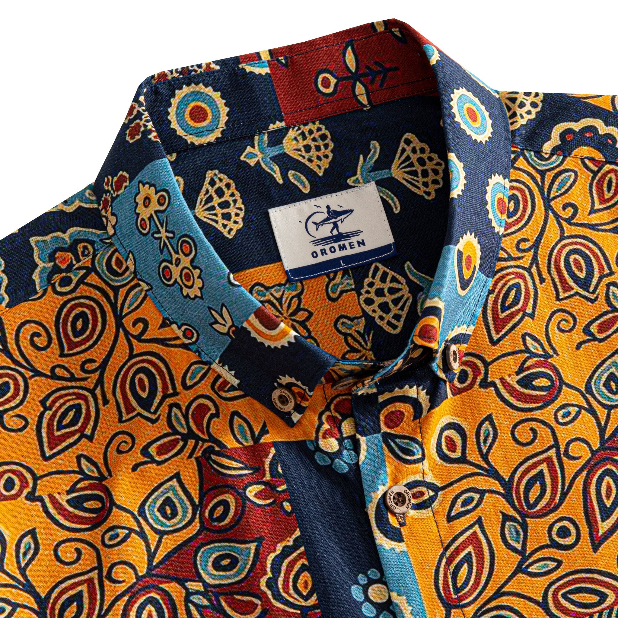 OROMEN Ajrakh Mosaic shirt button-down collar detail showing OROMEN branded label and multi-color Ajrakh patchwork panels in navy, amber and slate blue
