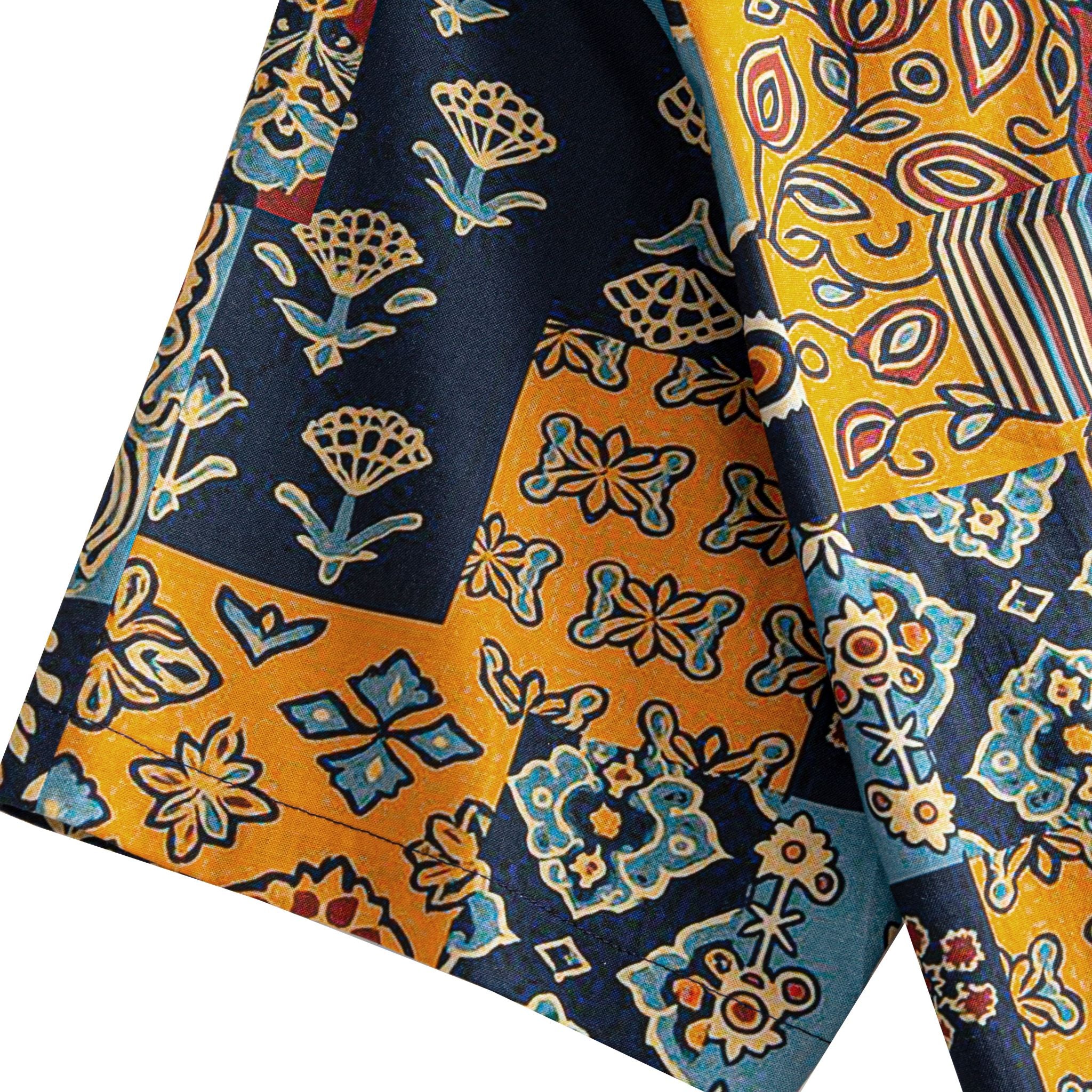 OROMEN Ajrakh Mosaic shirt sleeve detail showing multi-color Ajrakh patchwork motifs including paisley, floral and geometric blocks in navy, amber and slate blue cotton