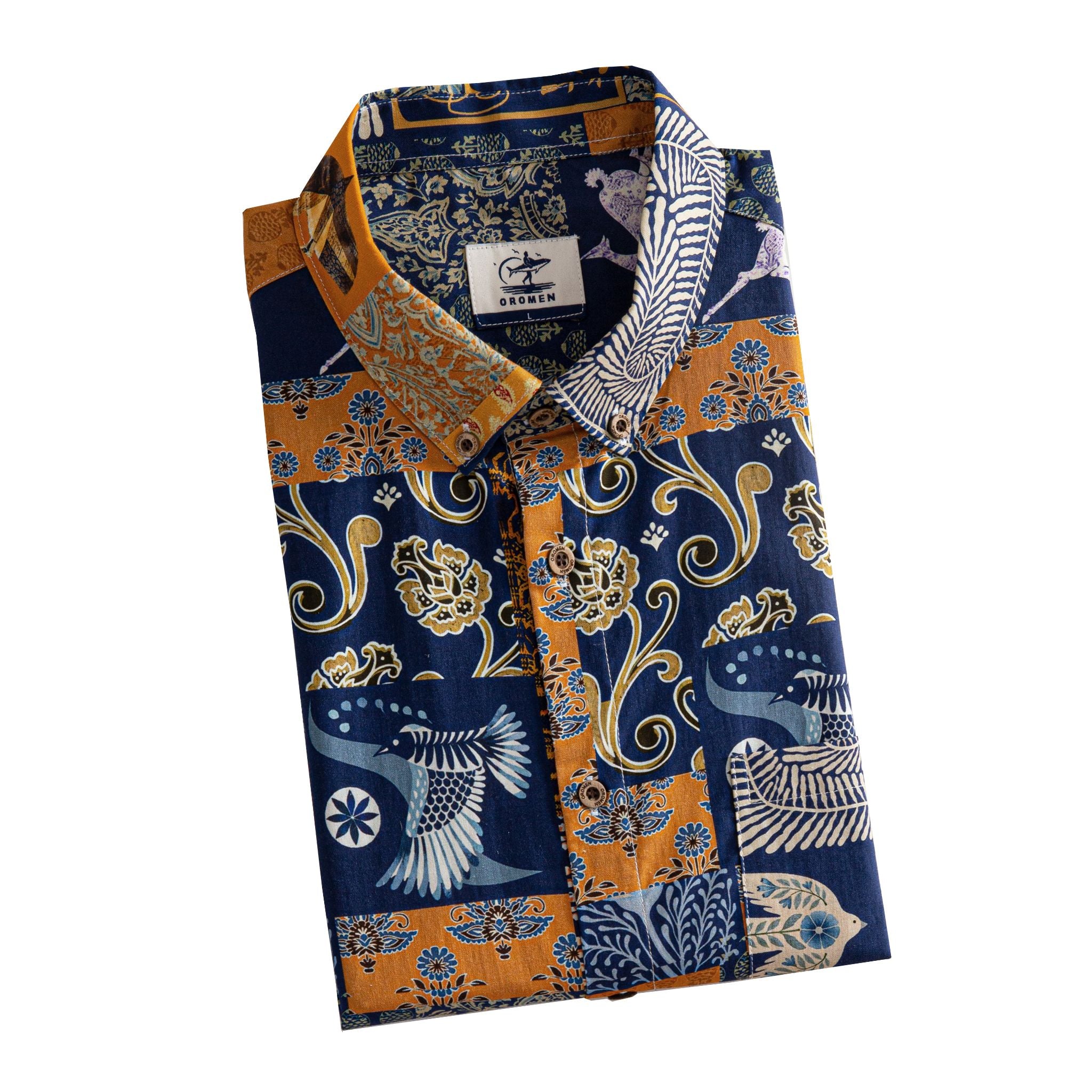 OROMEN Aviary Patchwork shirt folded display showing OROMEN branded label, coconut buttons and navy blue amber orange multi-motif patchwork print