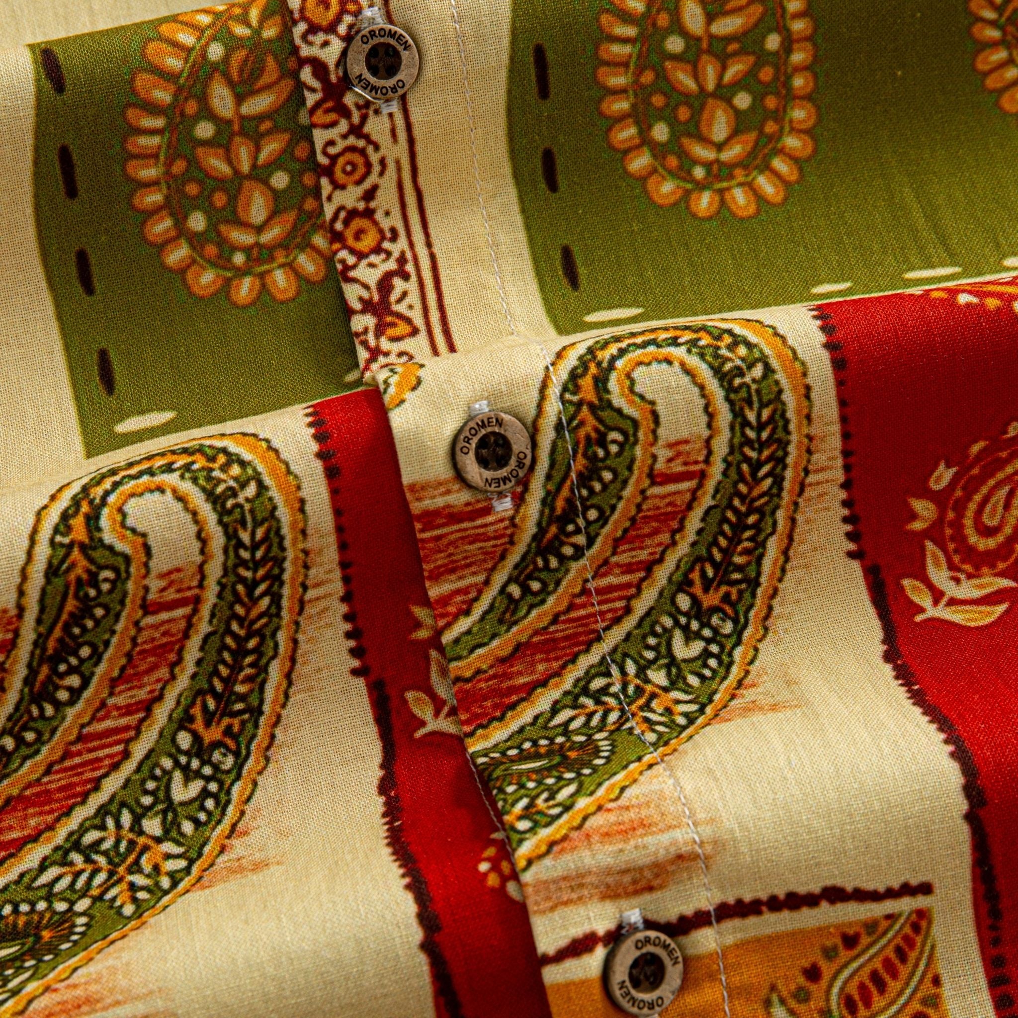 OROMEN Rajasthan Paisley shirt branded coconut button close-up against olive green and crimson paisley patchwork panels on cream cotton