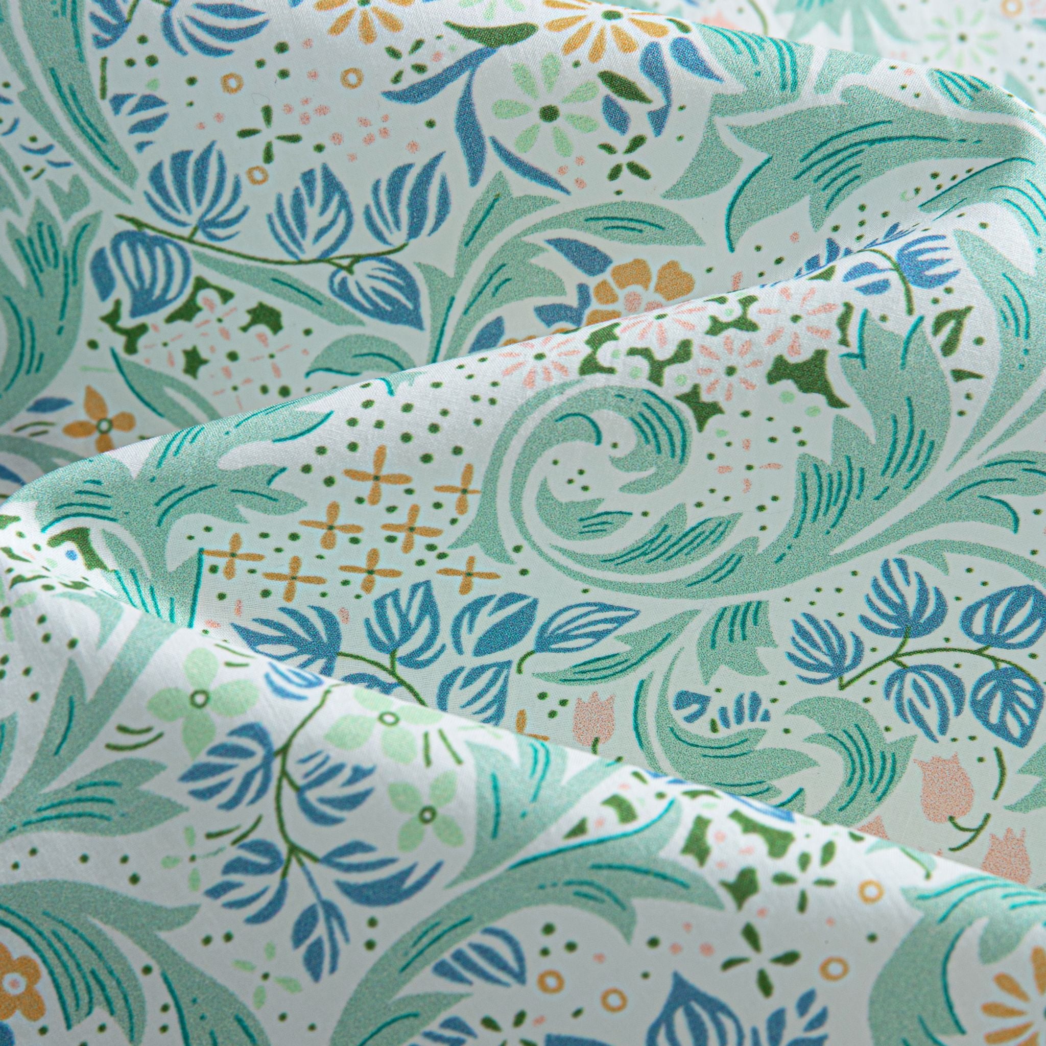 OROMEN-Rococo-Bloom-Hawaiian-shirt-close-up-of-hand-painted-Baroque-scroll-fabric-with-mint-green-vine-and-blue-floral-print-on-white-cotton