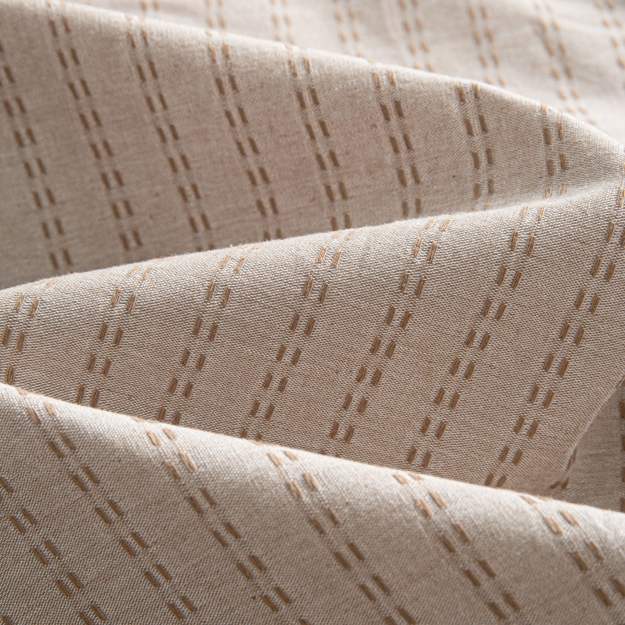 OROMEN Sashiko Natural shirt fabric close-up, warm tan Sashiko dash texture on natural oatmeal cotton