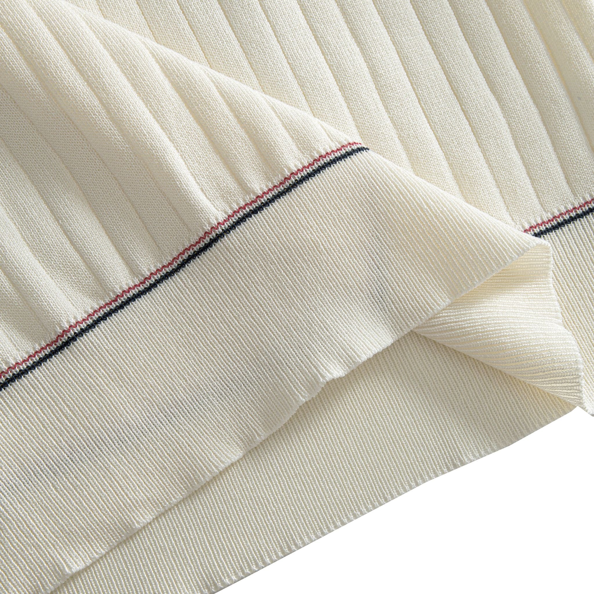 Ribbed hem close-up on OROMEN cream polo shirt, contrast stripe
finishing, fine vertical rib texture, clean structured edge