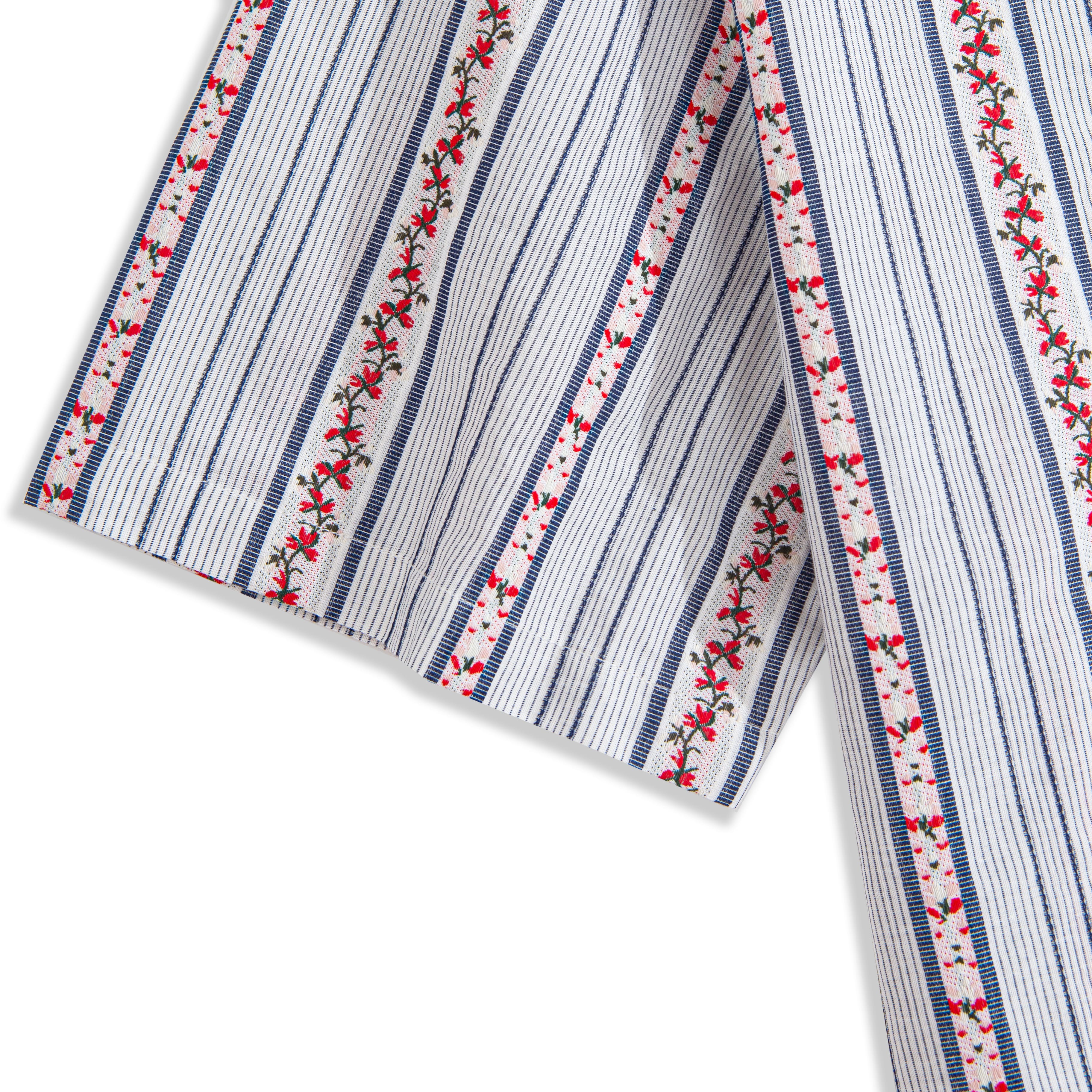 Side view of floral embroidered striped shirt showing box pleat detail