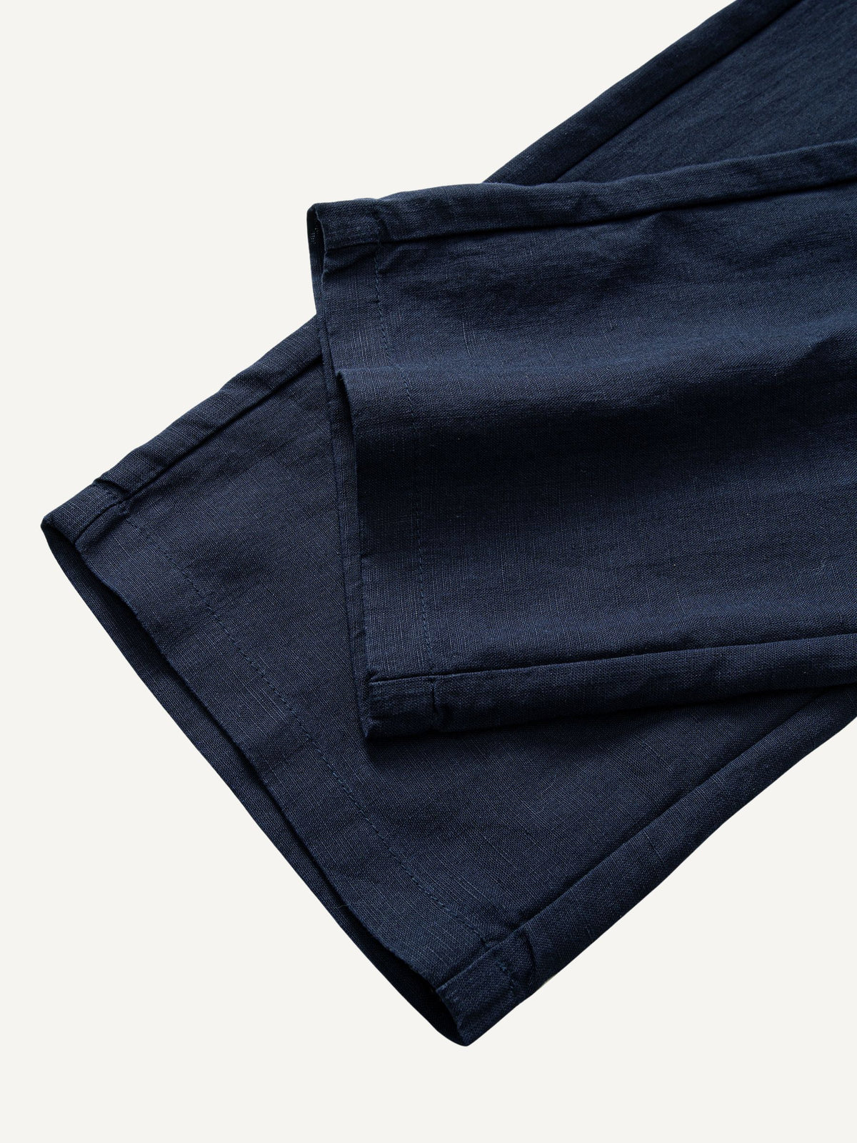 Tapered-leg-and-pre-rolled-cuff-hem-detail-on-OROMEN-Navy-Linen-Trousers