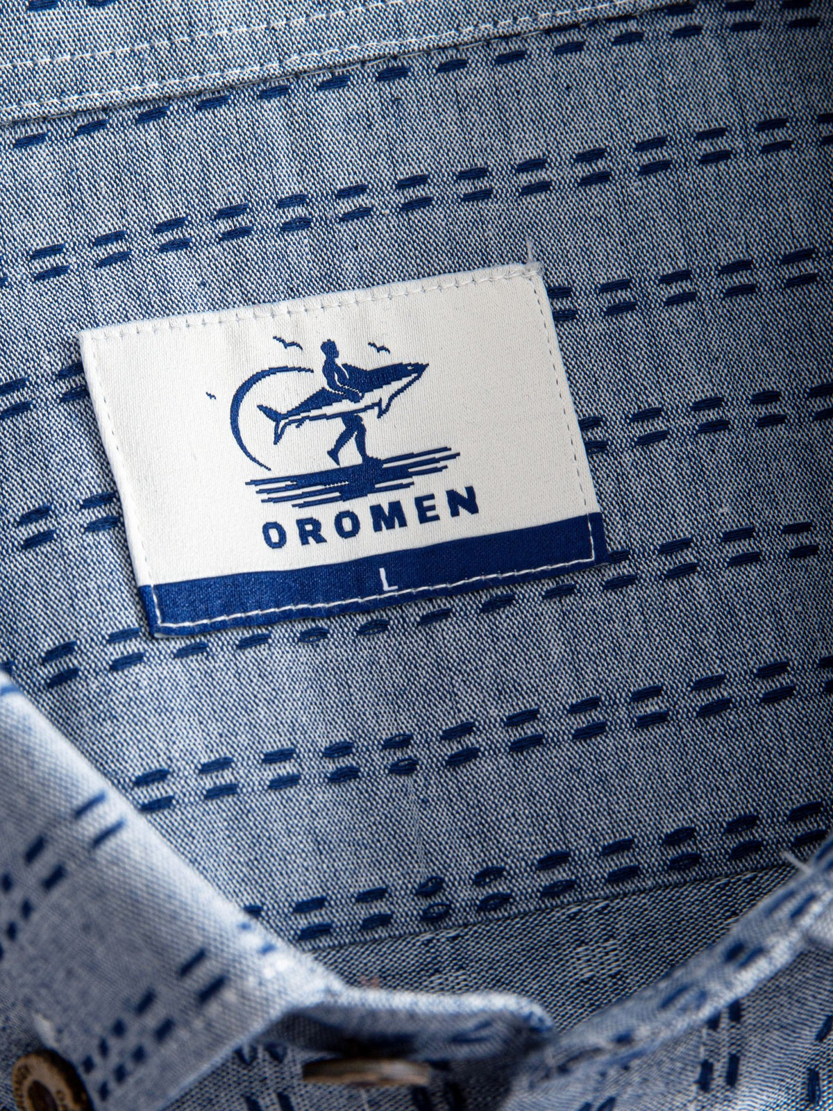 Woven neck brand label and inner collar detail of OROMEN Sashiko Chambray Cotton Shirt