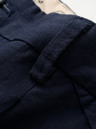 Belt loops and waistband detail on OROMEN Pleated Linen Trousers in Navy