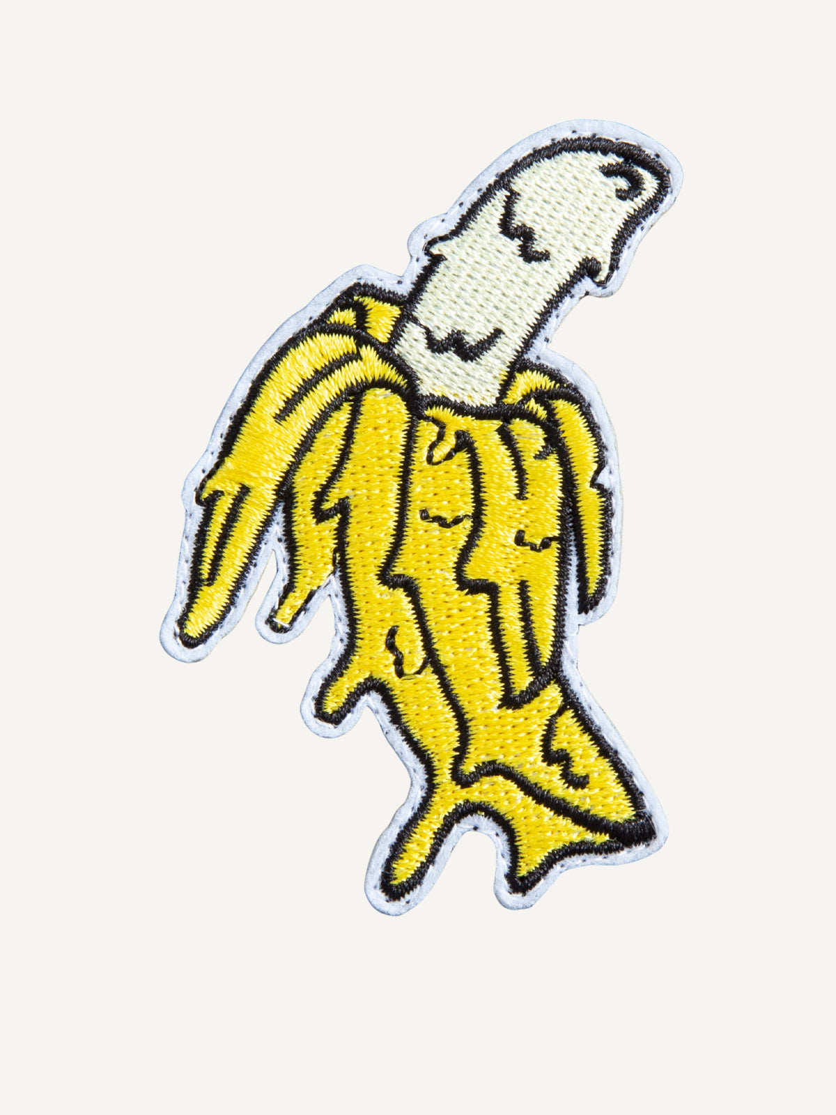 Boldly embroidered peeled banana artwork detail on OROMEN Tee