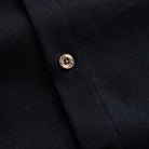 Button detail on men's black linen-cotton long-sleeve shirt, OROMEN natural coconut buttons