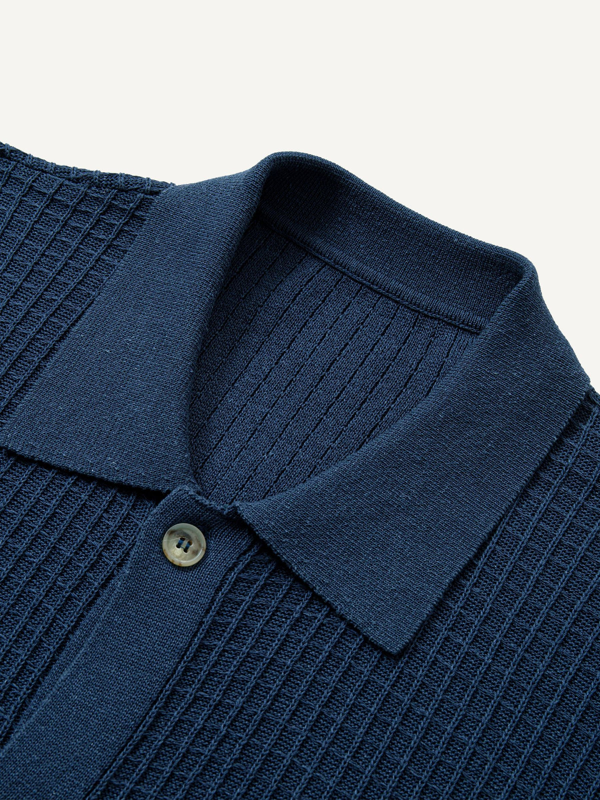 Close-up detail of classic ribbed polo collar and button placket on knit cardigan