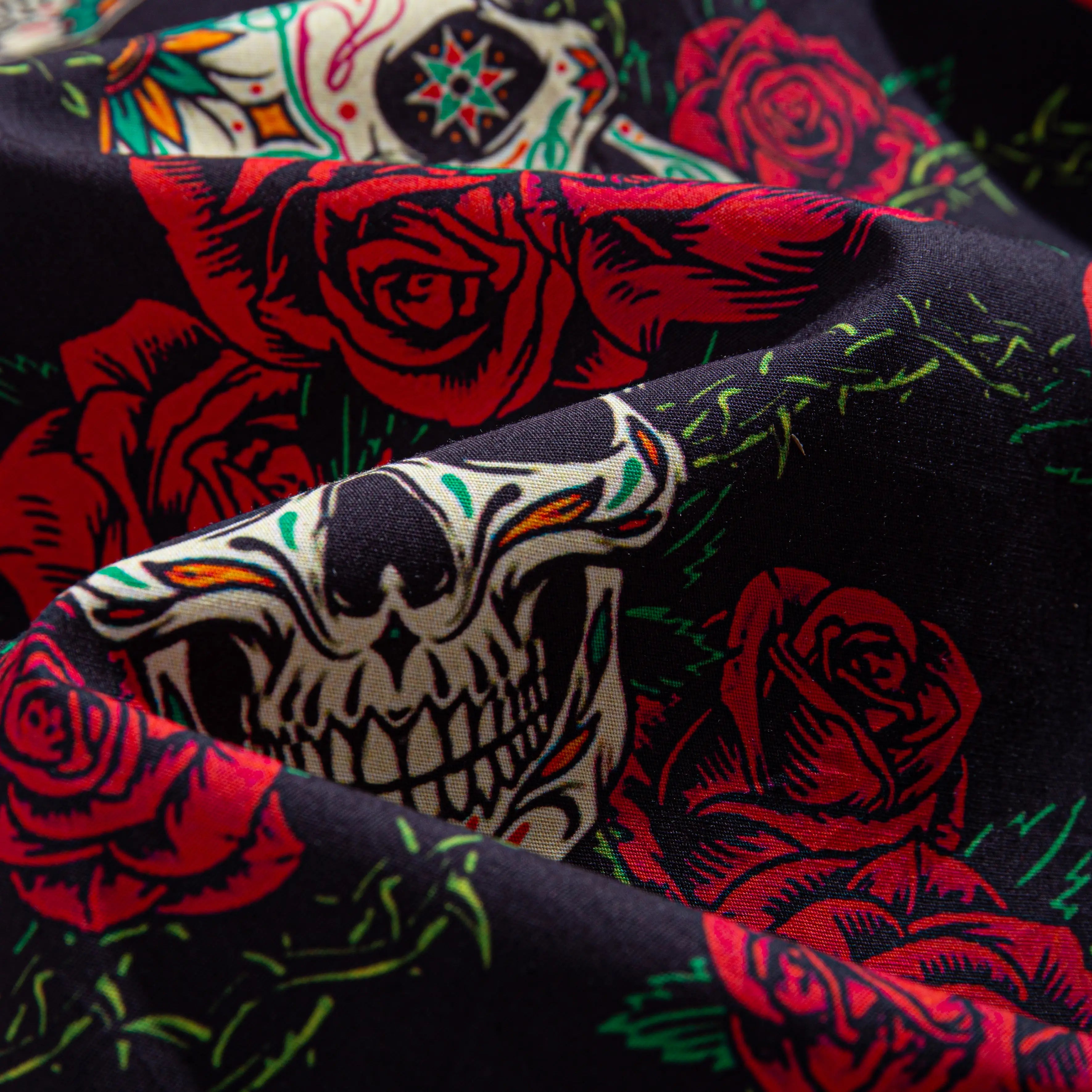 Close-up of OROMEN Bloom And Death shirt fabric – black sugar skull and red rose print with silky drape