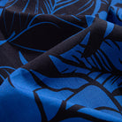 Close-up of OROMEN Blue Bush shirt fabric – blue and black tropical leaf hand-painted print