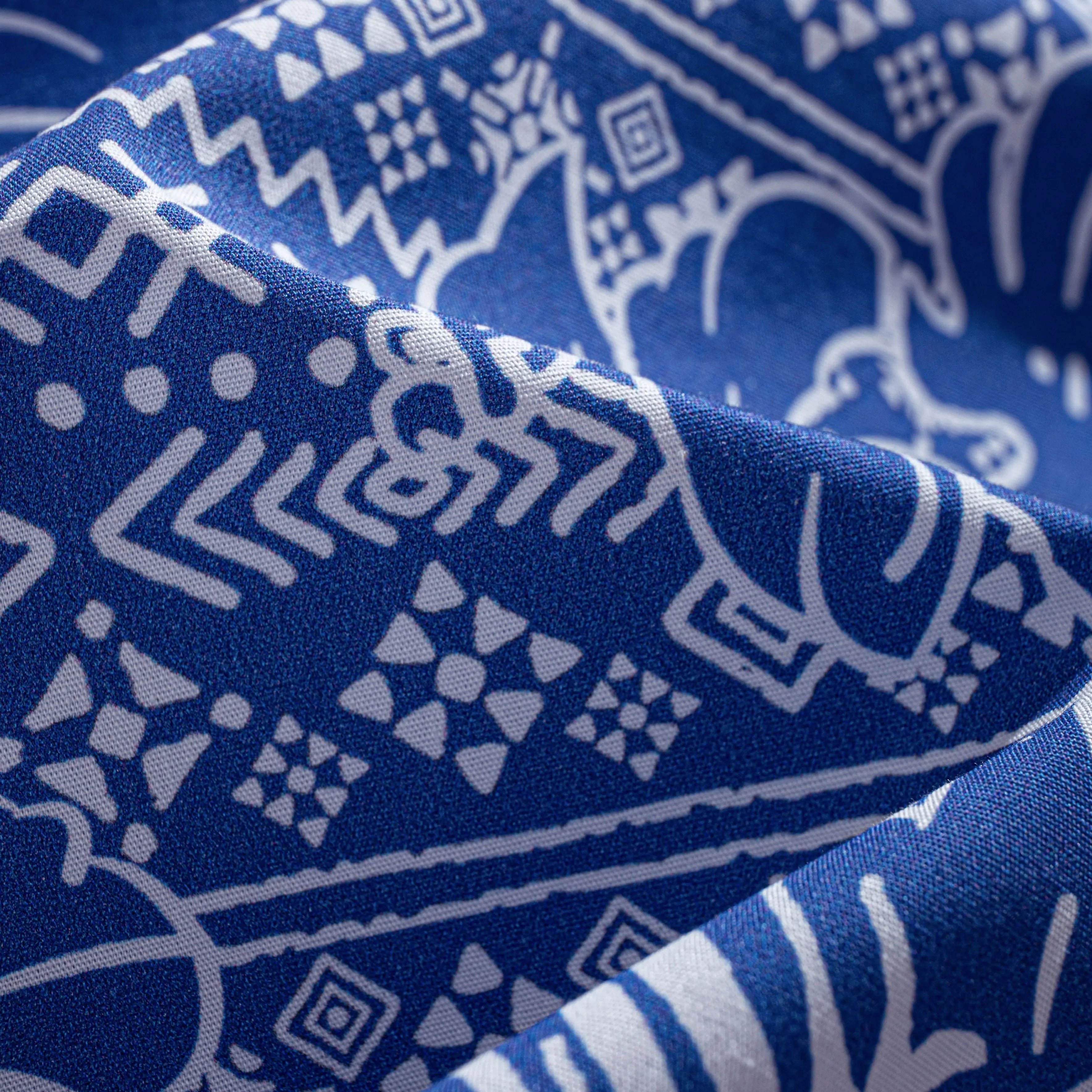 Close-up of OROMEN Plant Totem shirt fabric – navy blue hand-painted retro totem geometric print with silky drape