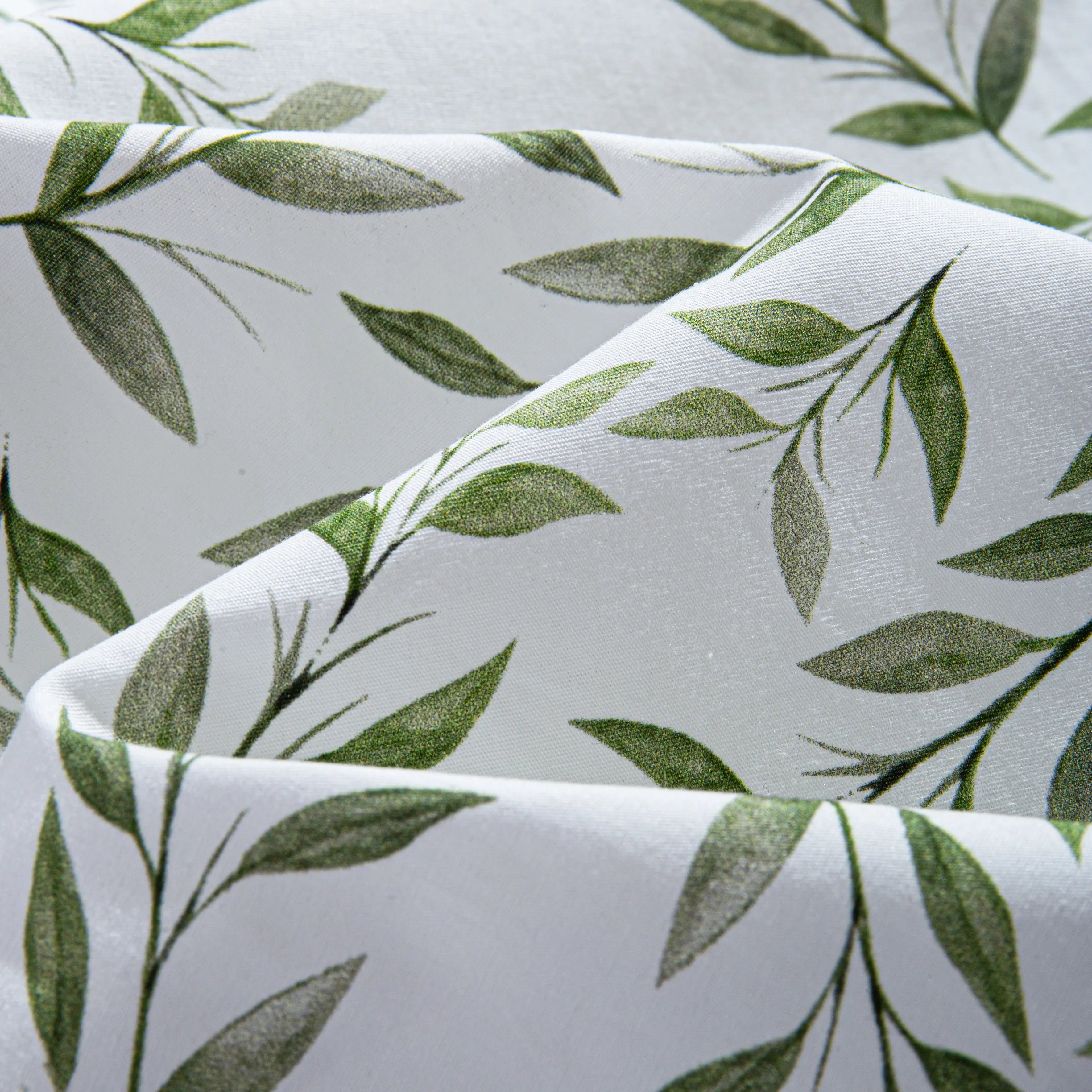 Close-up of OROMEN Willow Bough shirt fabric – green willow leaf print on white with soft silky drape