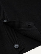 Close-up of clean ribbed hem on black contrast trim polo cardigan