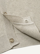 Close-up of clean ribbed hem on oatmeal contrast polo collar sweater cardigan