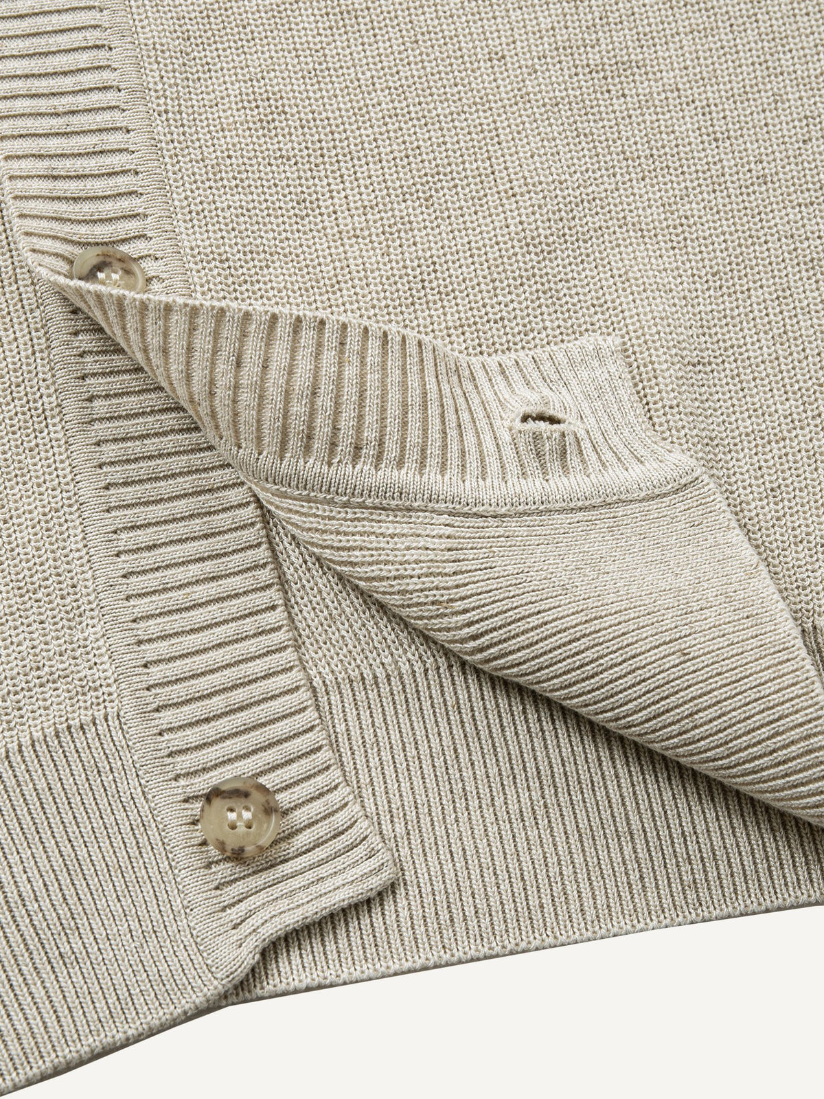 Close-up of clean ribbed hem on oatmeal contrast polo collar sweater cardigan