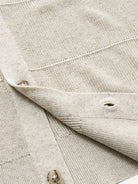 Close-up of clean ribbed hem on oatmeal horizontal textured knit cardigan