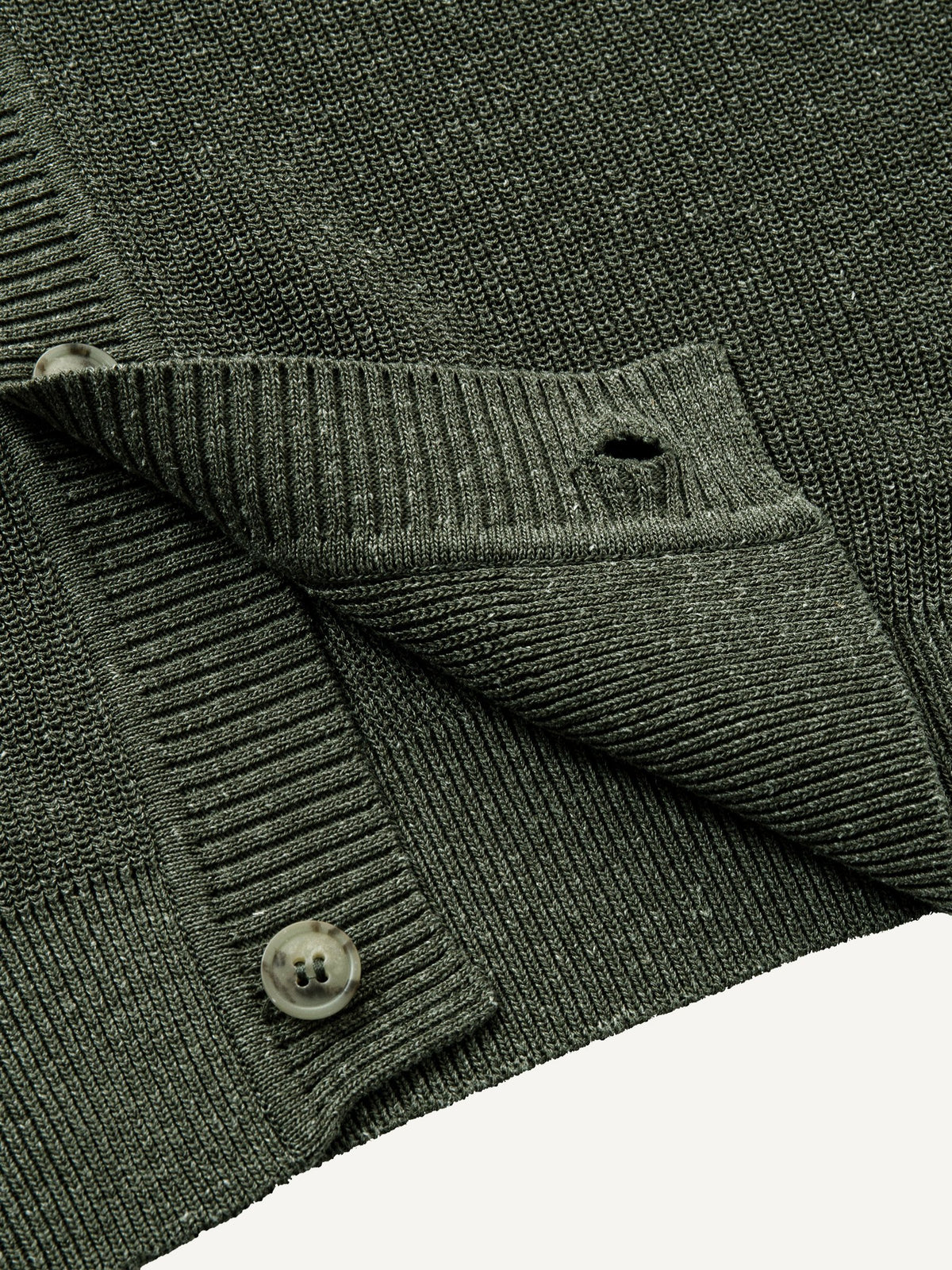 Close-up of clean ribbed hem on olive contrast trim polo knit cardigan