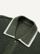 Close-up of contrast white trim on olive green polo collar knit cardigan