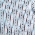 Close-up of embroidered flower bud pattern on vintage striped shirt