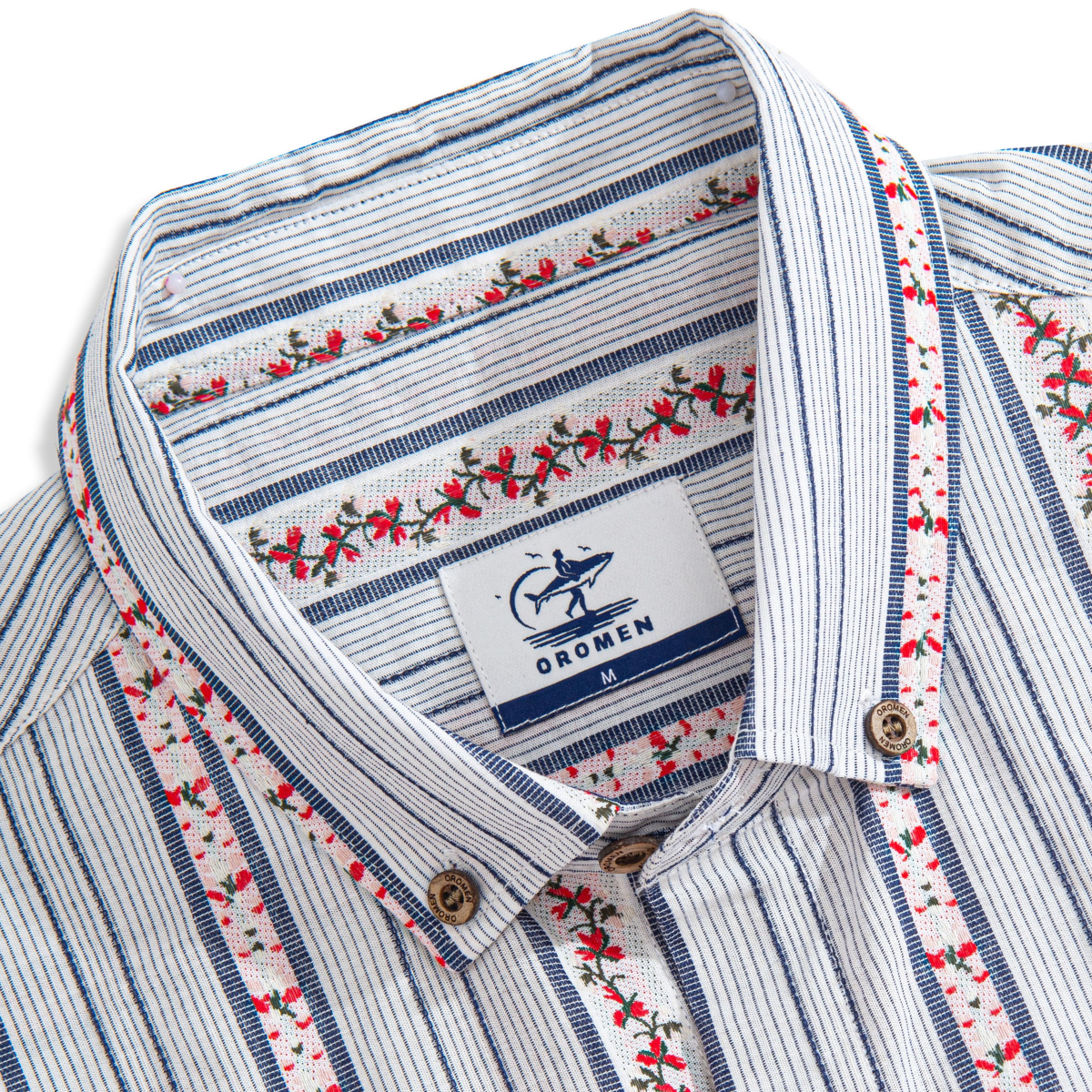 Close-up of floral embroidery and textured stripes on cotton shirt