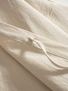 Close-up of functional cotton self-tie front closure on beige kimono jacket