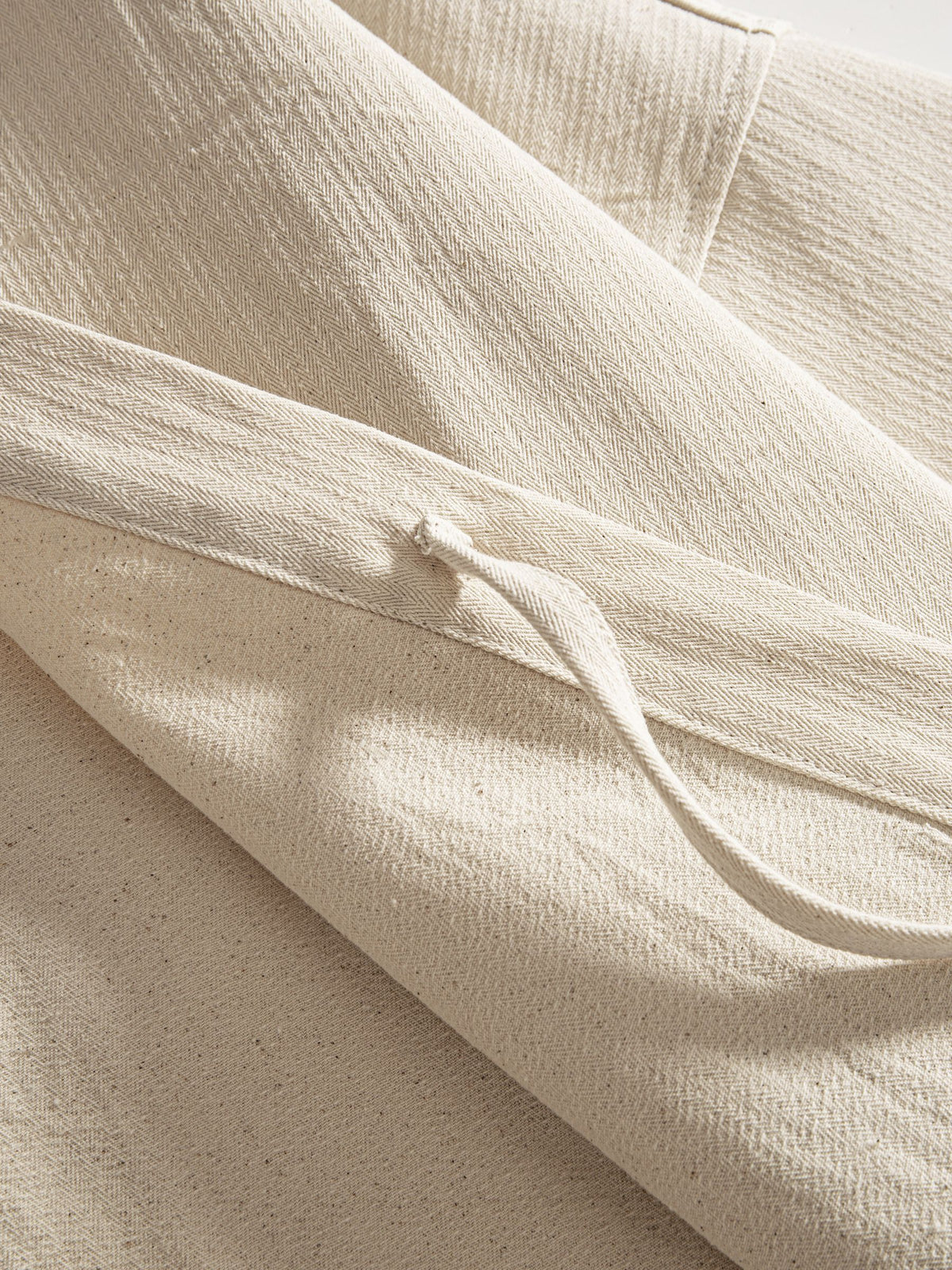 Close-up of functional cotton self-tie front closure on beige kimono jacket