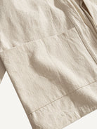 Close-up of generous front patch pocket on beige cotton kimono cardigan jacket
