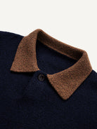 Close-up of heathered brown contrast polo collar and clean button placket on navy knit sweater