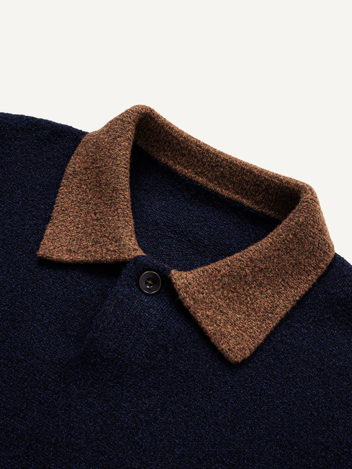 Close-up of heathered brown contrast polo collar and clean button placket on navy knit sweater