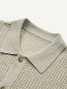Close-up of polo collar and front placket on beige ribbed sweater cardigan