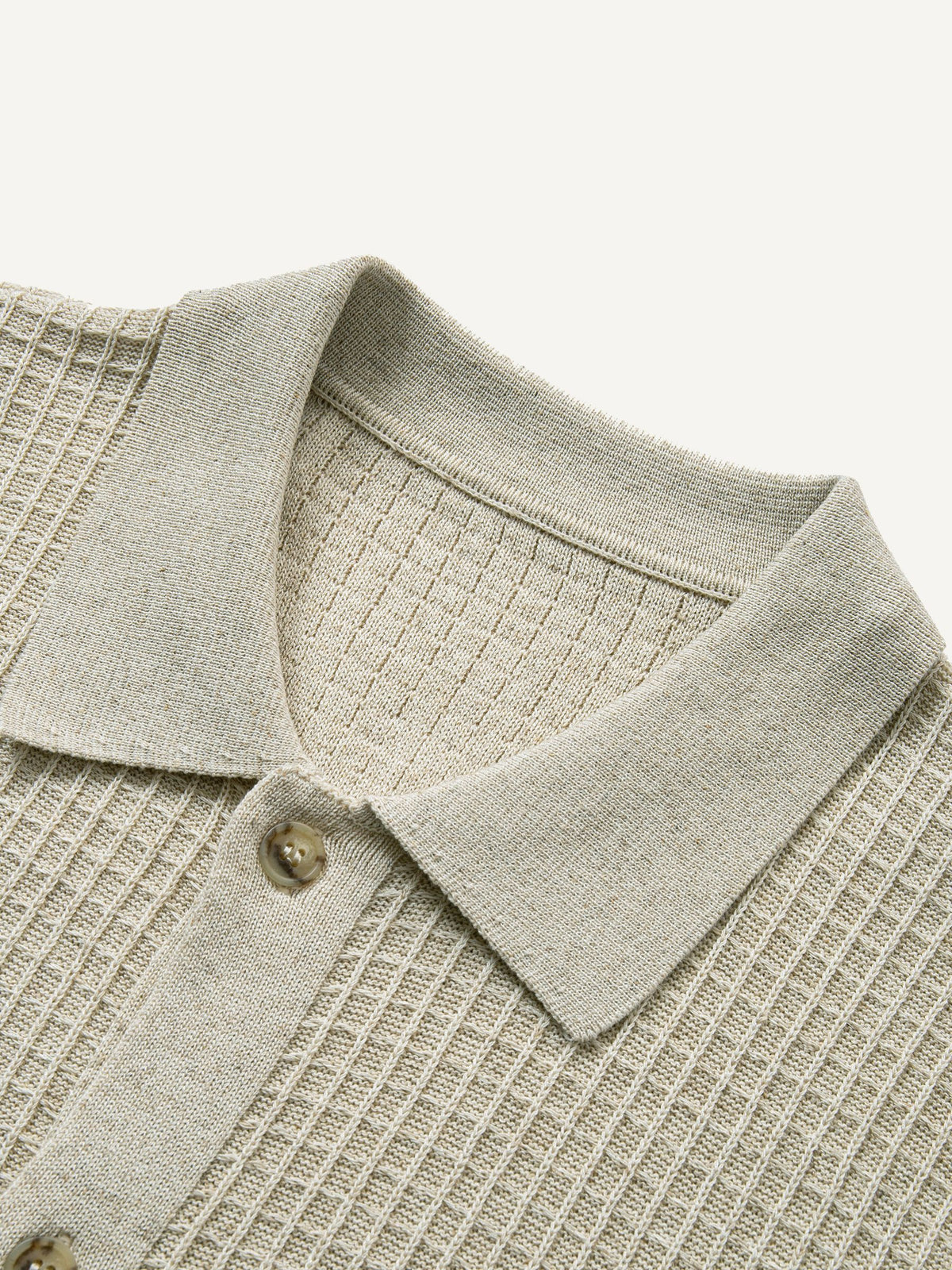 Close-up of polo collar and front placket on beige ribbed sweater cardigan