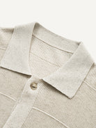 Close-up of refined polo collar and top placket on oatmeal textured knit cardigan