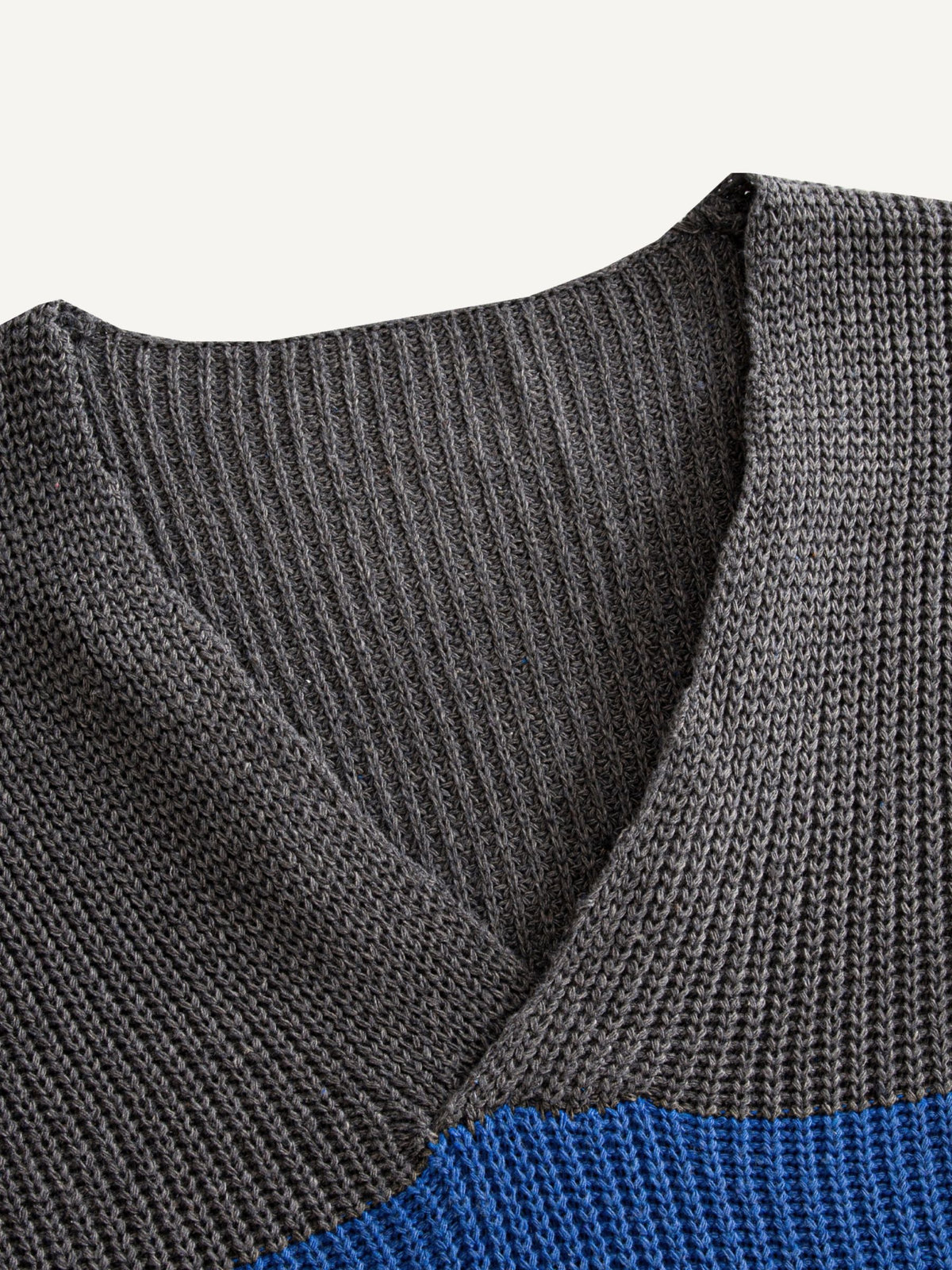 Close-up of ribbed V-neckline on colorblock striped jumper sweater