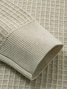 Close-up of ribbed knit elastic sleeve cuffs on beige button-down sweater