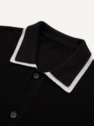Close-up of sharp white contrast polo collar on black fine-ribbed knit cardigan