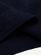 Close-up of the clean ribbed hem on navy stretch-knit polo sweater