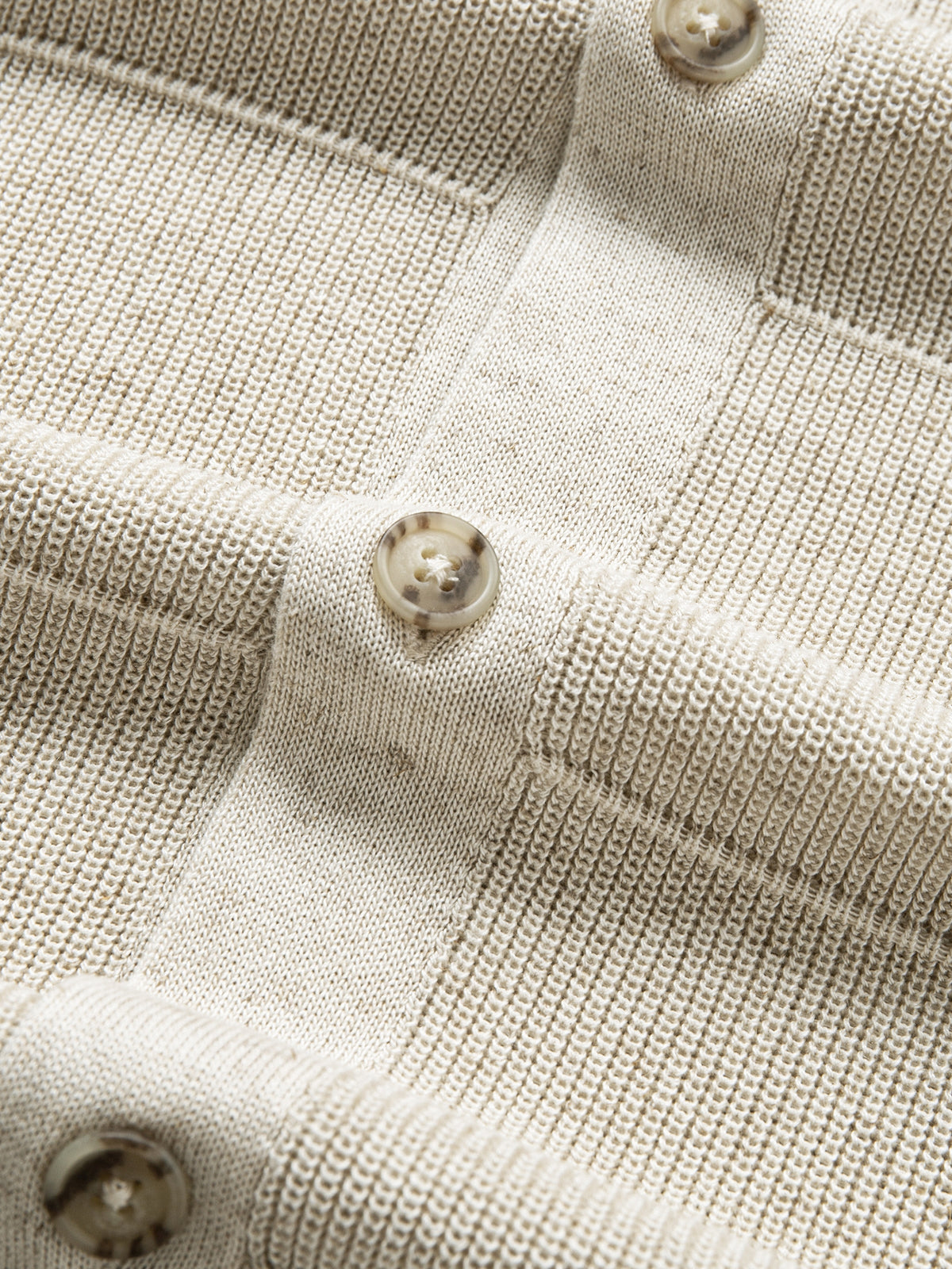 Close-up of tonal front button closure along the placket on oatmeal knit polo cardigan