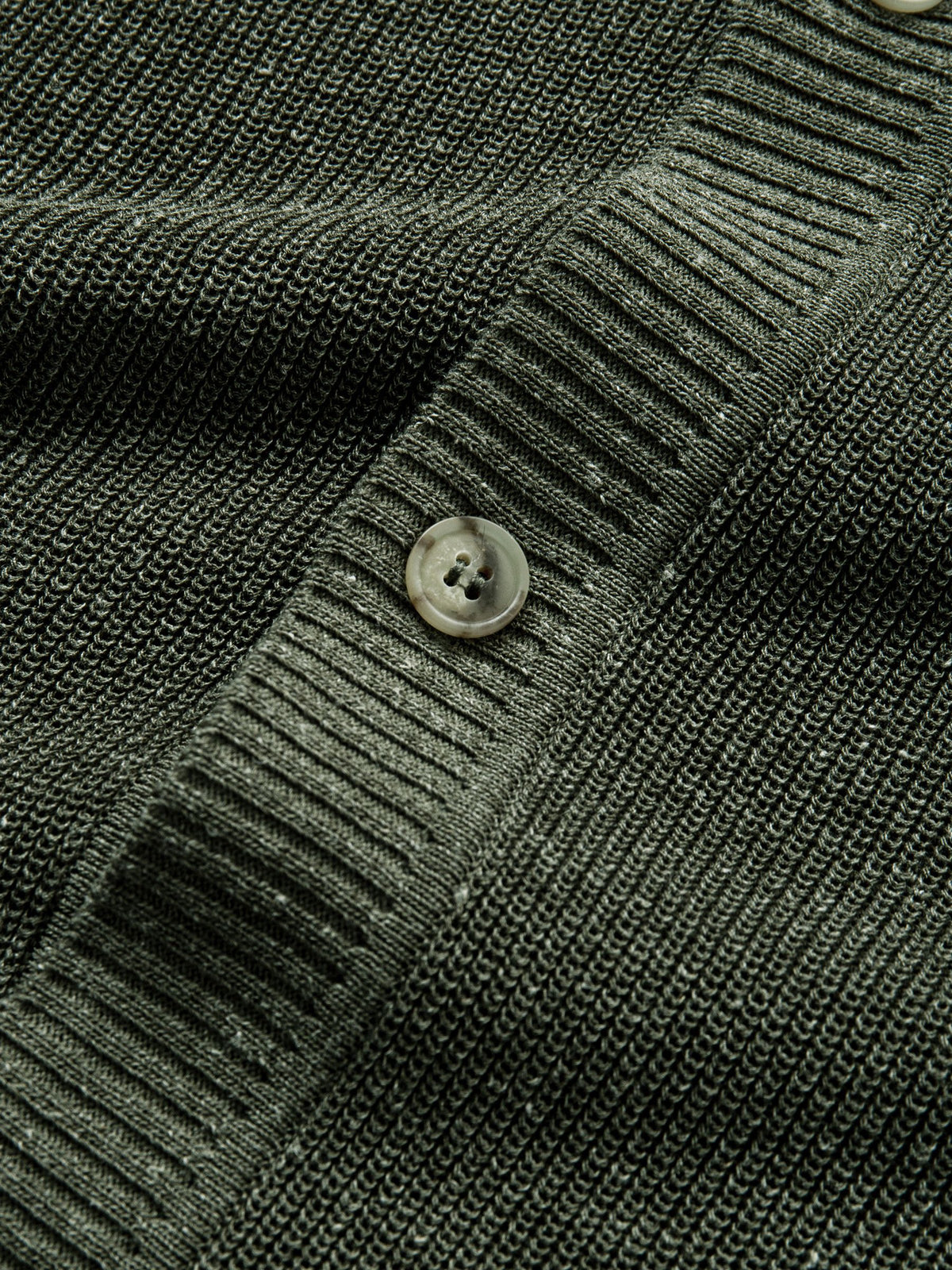 Close-up of vintage button closure along the front placket on olive knit cardigan