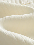Close-up texture of ice silk fine rib knit fabric on OROMEN Cream Court Knit Polo