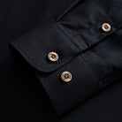 Cuff detail with OROMEN branded coconut buttons on black linen-cotton woven shirt