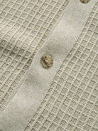 Detailed close-up view of front button closure and textured ribbed placket